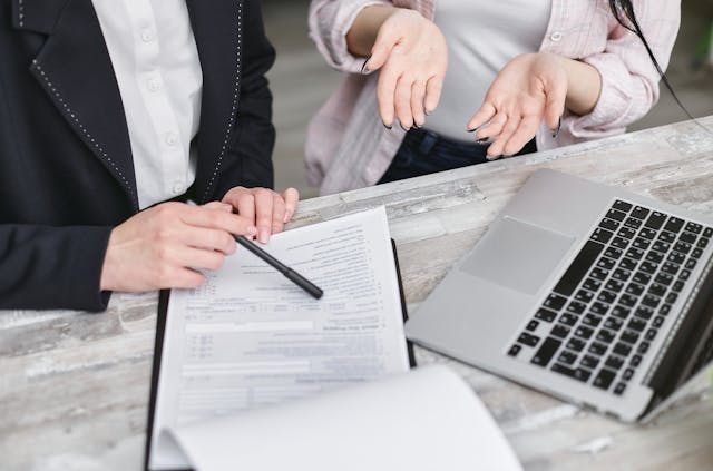 meest gemaakte verzekeringsfouten: adviseur en vrouw die verzekeringspapieren invullen